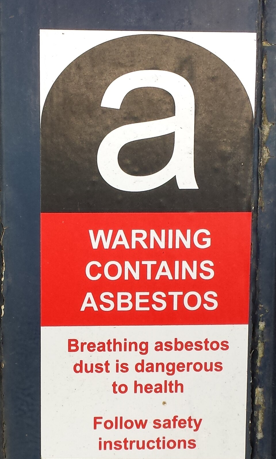 Warning label marking a material that contains asbestos